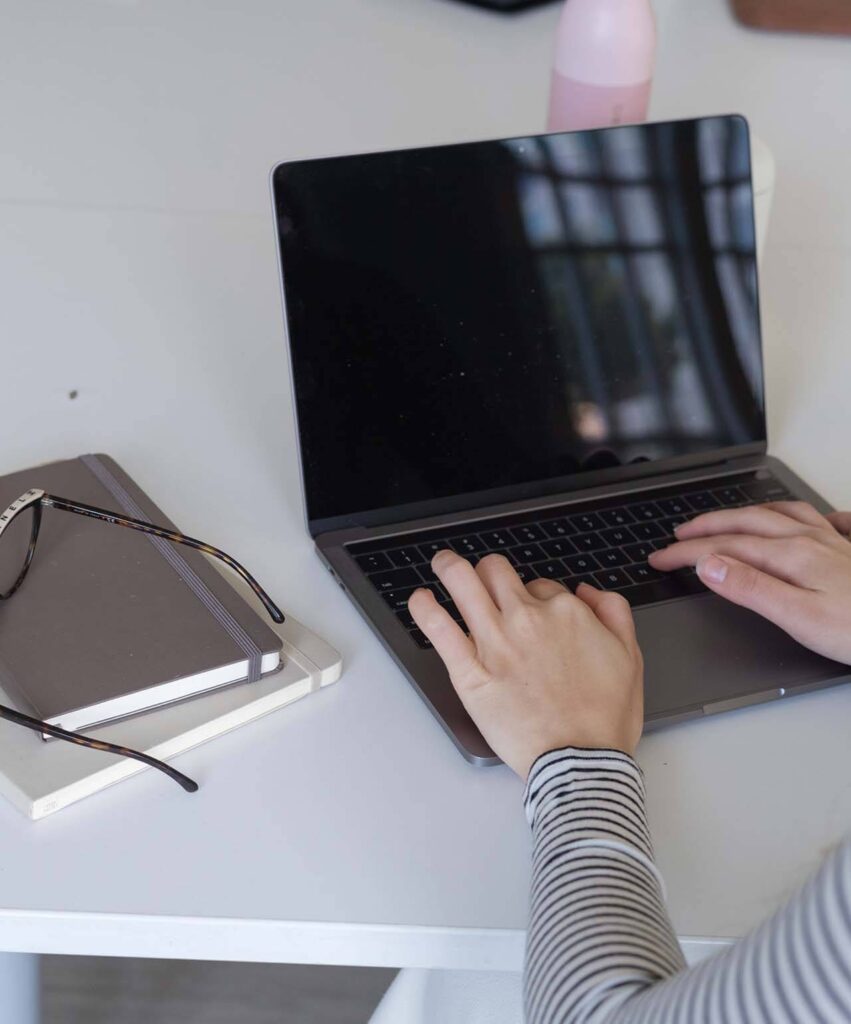 Photo of a qualified freelancer working on a laptop. Boutique translationas through a